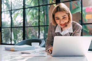 dame leest glimlachend op haar laptop